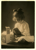 Portrait of Baltimore, Maryland, photographer Emily Spencer Hayden's daughter Anna Bradford Hayden, also known as "Nan," with a Brownie camera and box. Verso transcription: Nan Hayden. 7 years old I think