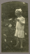 Baltimore, Maryland, photographer Emily Spencer Hayden's daughter Anna Bradford Hayden, also known as "Nan," standing in a field of flowers. Verso transcription: Anna Bradford Hayden