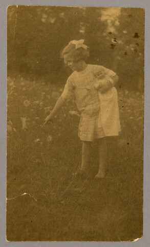 Anna ‘Nan’ Bradford Hayden (Agle) holding doll and picking wild flowers — circa 1905-1922