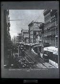 Elevated street view of Baltimore Street between St. Paul Street and Calvert Street in downtown Baltimore, Maryland. Visible in the photograph are businesses such as: Murphy & Co. (publisher); Geo. P. Steinbach (importer); Samuel Hunt & Sons (trunks, harnesses, saddles); and, possibly, Farrell's (confectionery).