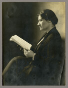 Portrait of Elizabeth Foreman Lewis, legs crossed and reading.