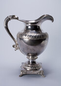 Pitcher of coin silver made by Philadelphia silversmiths Fletcher & Gardiner (1812-1817). Part of a $4,000 52-piece service presented to Commodore John Rodgers (1772-1838) on the 3rd anniversary of the bombardment of Fort McHenry and the Battle of North Point, 1814. Inscription on bottom.