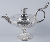 Ornate silver coffeepot with a swan finial and seahorse on the spout. Part of a three-piece silver service set belonging to the McKim family. Made in Baltimore, Maryland, by Samuel L. Kirk.