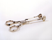 Pair of scissor-style sugar tongs embellished on the hinge with a floral design. Monogrammed on the bowl with the initials "P.W."