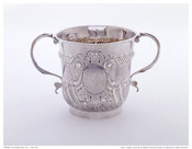 Two-handled cup with gadrooned and beaded body. Central medallion with initials of owner surrounded by embellishments in relief.