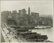 Elevated street and harbor view looking north-northeast along Light Street, Baltimore, Maryland. Showing automobiles, horse-drawn wagons, a ship, auction mart, the Keystone Electric Company, the New Fountain Hotel (122 East Pratt Street), the Neudecker Tobacco Company, the American Oil Company and the city skyline to the east.