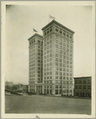 View of the Standard Oil Company building located at 505 St. Paul Street, Baltimore, Maryland. Automobiles can be seen parked around the building.