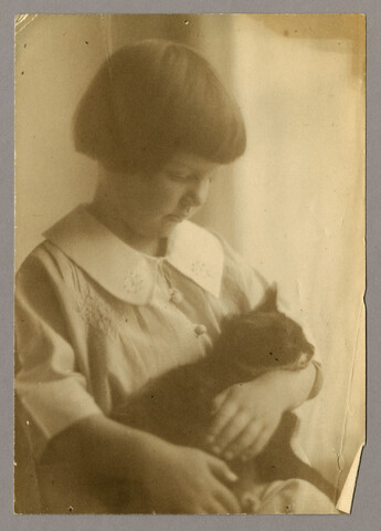 Portrait of young child with cat — undated