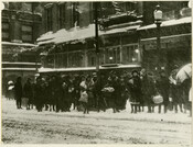 Street scene of shoppers waiting for a trolley at Howard Street and Lexington Street in Baltimore, Maryland, during the blizzard of 1922. Also known as the "Knickerbocker" storm, this nor'easter brought record snowfall to the Baltimore region, with areas seeing up to 24 inches of snow in 24 hours.