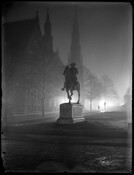Nighttime view of the statue of American soldier and politician John Eager Howard in Mount Vernon Place, Baltimore, Maryland. The statue features Howard in his military uniform, mounted on a horse, with his right arm outstretched and finger pointed.