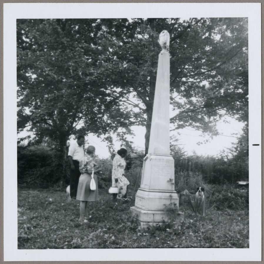 Three unidentified people and a dog visiting the memorial of Henry Jakes ( - June 22, 1881) and son, Frederick Jakes ( - August 19, 1865).