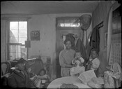 A group portrait of a woman with four children inside of a home.