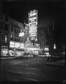 Evening street view of Keith's Theatre, located at 114 West Lexington Street in Baltimore, Maryland. The theater was also known as the Garden Theatre, New Garden Theatre, and Keith-Albee Theatre. The brightly lit sign and marquee advertise for the film Nagana and read, "Keith's / Nagana with big cast / Tala Birell / Melvyn Douglas…