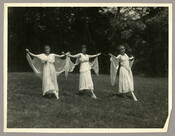 Three dancers from Goucher College performing “Cupid and Psyche," from a series of photographs by the Baltimore, Maryland, photographer Emily Spencer Hayden. A note on back of one of the photographs states that the women’s performance stopped traffic on Edmondson Avenue. The students were probably part of a group called the “Dickens Club.” Verso transcription:…