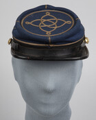 This post-Civil War blue kepi cap with gilt braid and buttons belonged to Edwin W. Moffett (1839-1880) of Baltimore, Civil War Captain in the 8th Maryland Volunteer Infantry.
