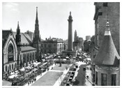 An elevated view of the Flower Mart (May Mart) from the Washington Apartments at 700 North Charles Street, Baltimore, Maryland. Shows the Washington Monument and the Methodist Church located at 2-8 Mt. Vernon Place. View is from the northwest corner of Charles and Madison Streets. The Flower Mart is an annual local festival founded by…