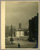 View of downtown Baltimore, Maryland, home of the photographer Emily Spencer Hayden. Fire hydrant, streetlight, cars, and buildings are visible. Verso transcription: Baltimore - Downtown
