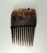 Decorative tortoise shell hair comb carved with a floral motif.