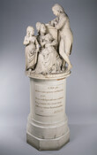 Sculpture of the wealthy German merchant Mayer family including the father, Christian, standing, his wife seated. Their son Leavis is sat on her lap and their daughter Anna Maria is standing at her right hand. The group of figures sits atop a cylindrical pedestal inscribed with lyrics from Homer.