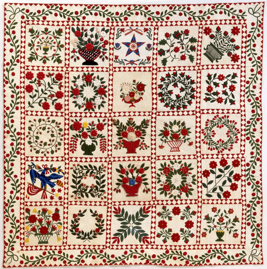 Baltimore album quilt made in Baltimore, Maryland with a five-by-five block scheme, traditional red and green colors, and a fruit-and-vine border. The blocks feature motifs typical to the style including wreaths and vases of flowers as well as more unique squares like the star block in the top row.