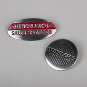 Metal and enamel employee pins made for the Maryland department store Hutzler Brothers Company (1858-1990), c. 1960-1980, by the Irvin H. Hahn Corporation (1898- ) of Baltimore. The round "Hutzler's" pin was the employee standard for many years.